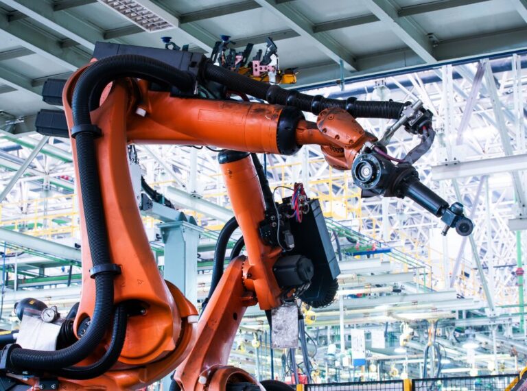 A large robotic arm within a manufacturing facility is ready for its next task.