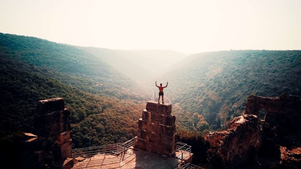 man standing on large bricks overlooking mountains