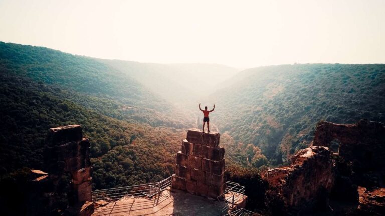 man standing on large bricks overlooking mountains