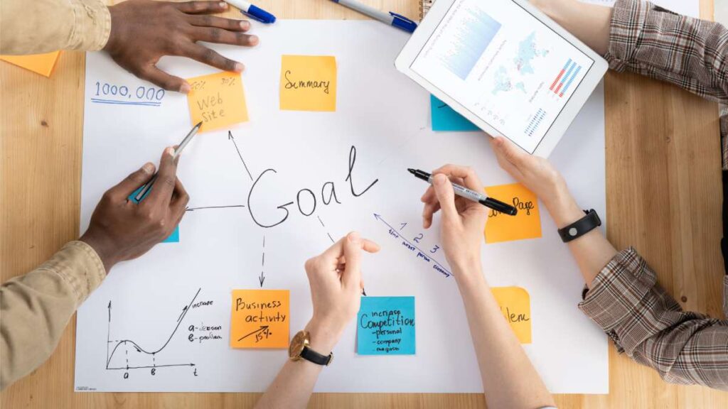 overhead view of b2b marketers setting goals for their business on a poster board