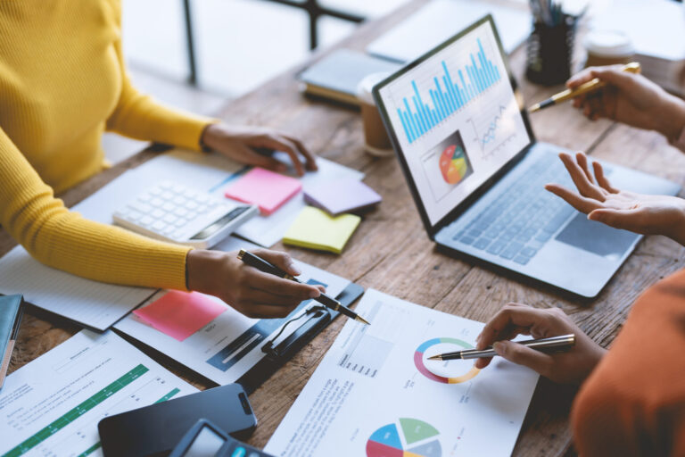 Close up of hands business people working together in on marketing budget strategy.