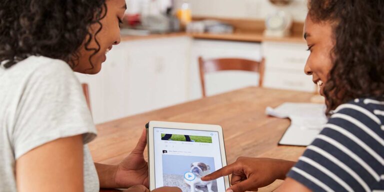 smiling women looking at dog video on social media