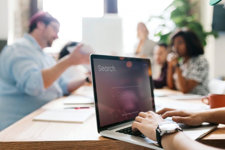 person with search engine open on laptop at a business meeting