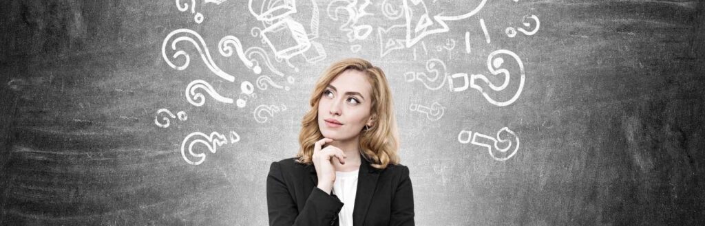 woman thinking with with question marks on whiteboard