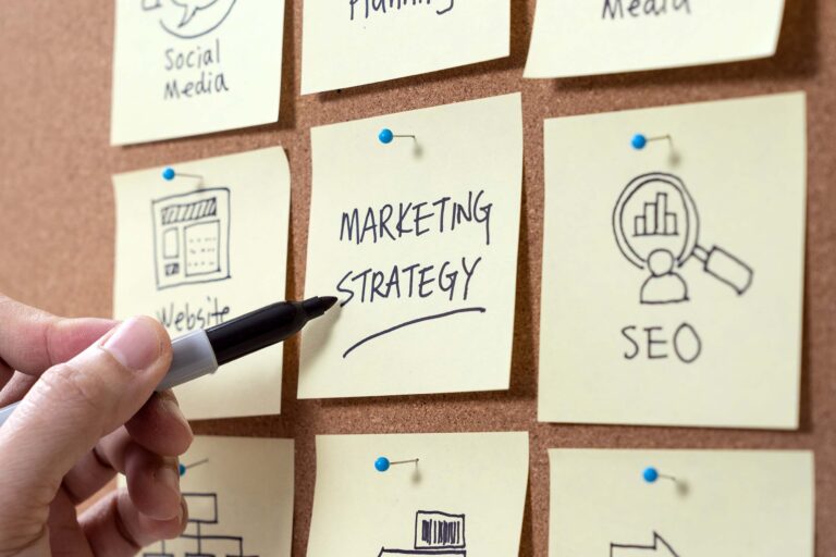 cork board with sticky notes reading marketing strategy, seo, social media, and more